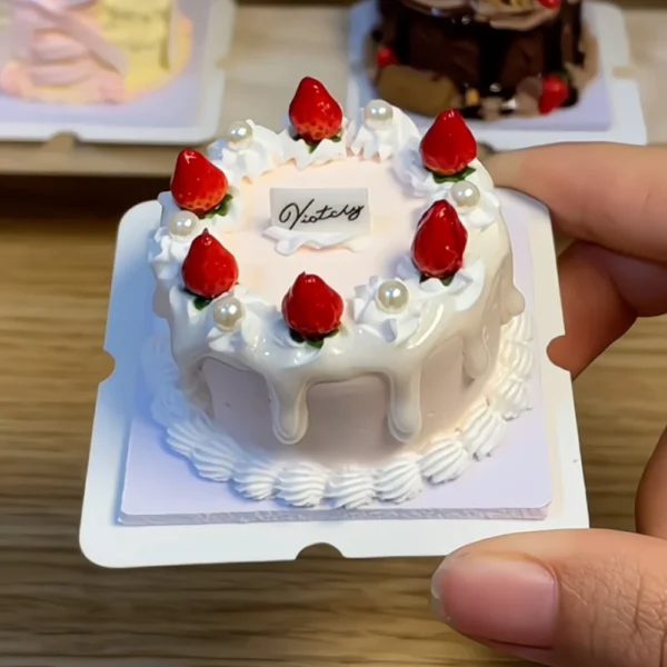 Finished example of a DIY miniature clay strawberry cake kit with white cream-style frosting, red strawberry details, and pearl-like decorations Finished example of a DIY miniature clay strawberry cake kit with white cream-style frosting, red strawberry details, and pearl-like decorations