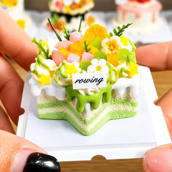 Sample finished piece from a DIY Miniature Citrus Star Cake Kit featuring green drip icing, fruit-inspired decorations, flowers, and a star-shaped cake design.