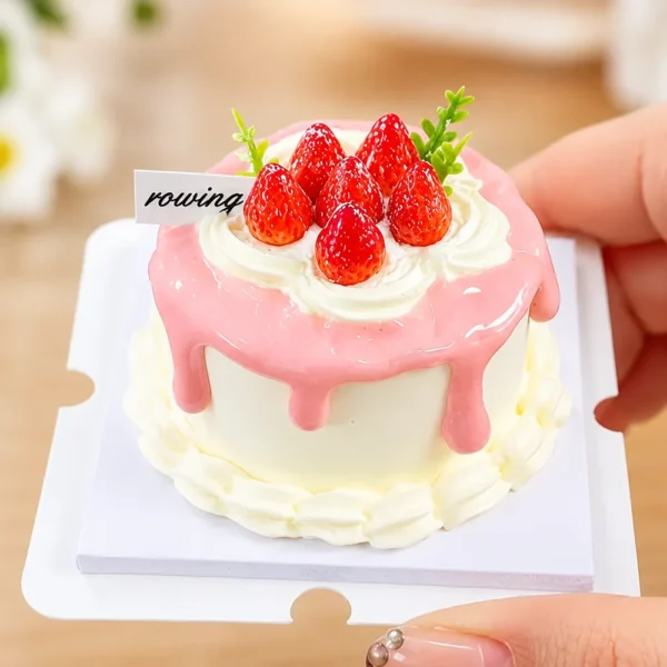 DIY Miniature Strawberry Cake Kit Finished Example Finished example of a DIY miniature strawberry cake kit with pink drip topping, cream-like details, red strawberries, and green accents