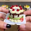 Sample finished piece from a DIY Miniature Strawberry Chocolate Drip Cake Kit featuring cream-style decorations, chocolate drip details, and strawberry accents.